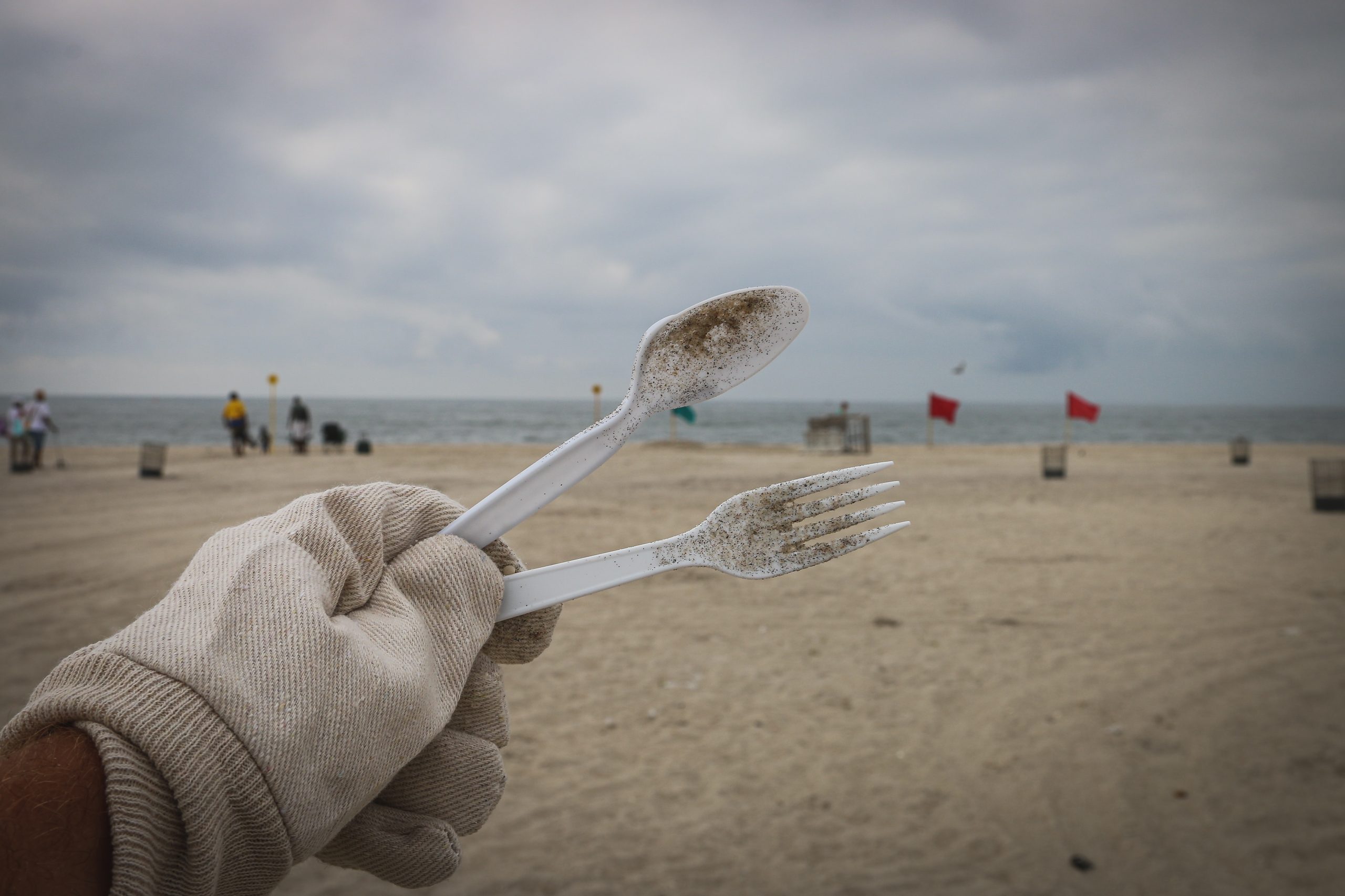 Cleaning up plastic utensils from a beach