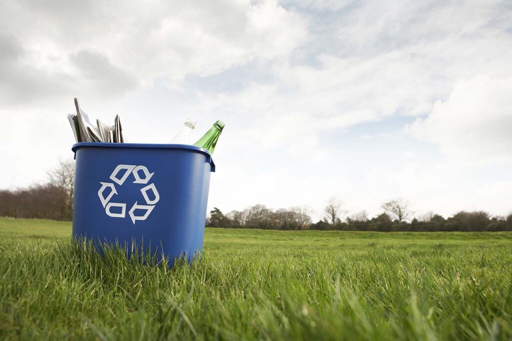 Blue recycling bin in a field