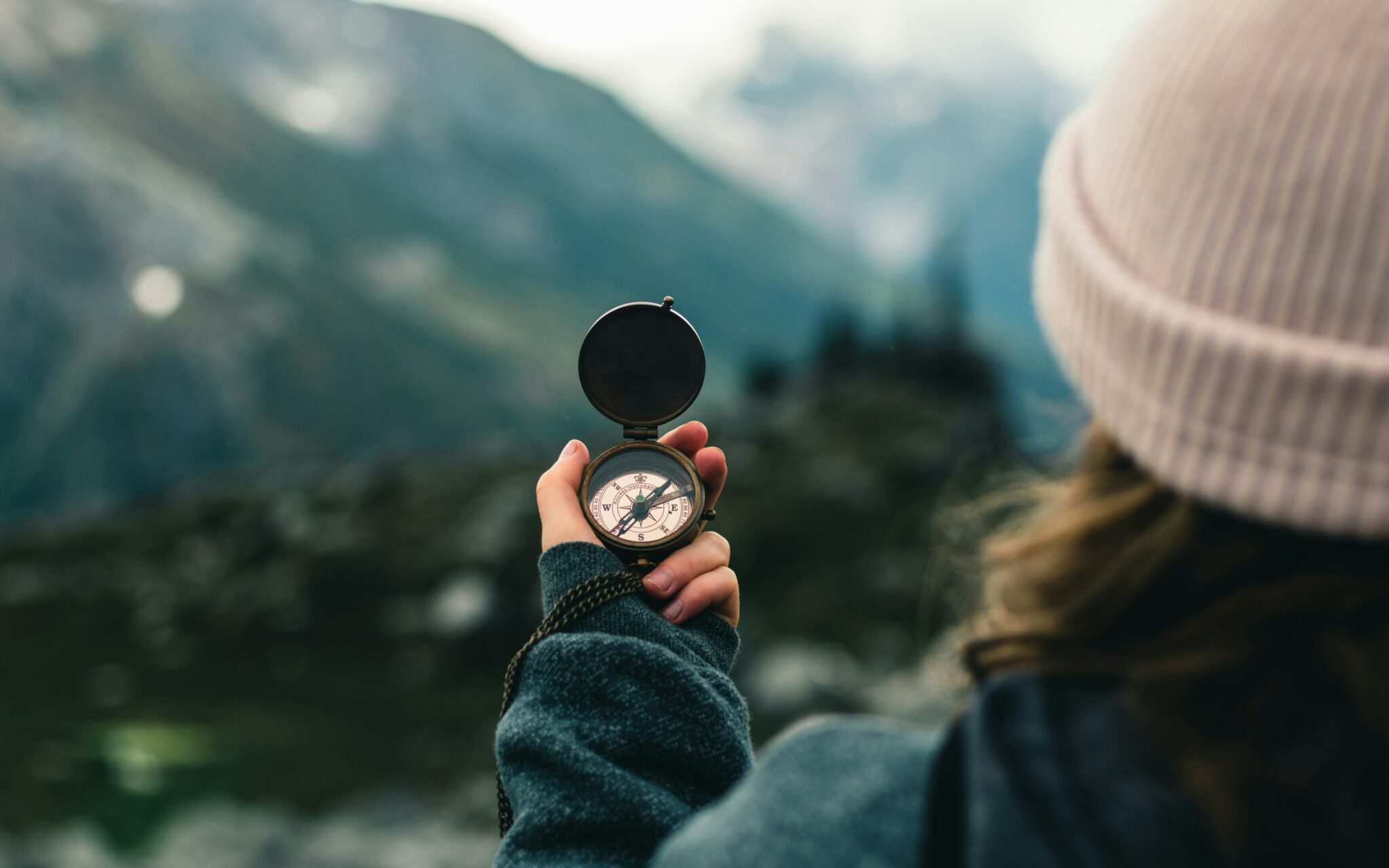 A person holding a compass outdoors